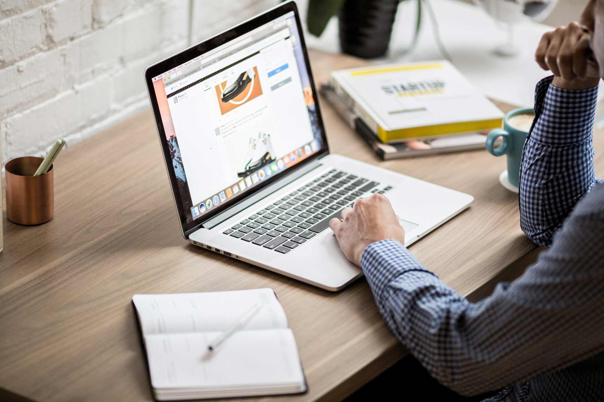 This is an image of a man at a desk using a laptop computer.