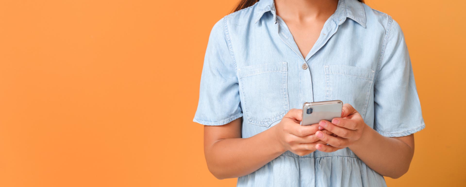 This is an image of a young woman using a smart phone.